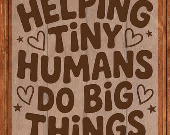 May include: Brown text on a transparent background reads "HELPING TINY HUMANS DO BIG THINGS." The text is in a playful font, with hearts and stars as decorative elements. The background is a wooden surface.