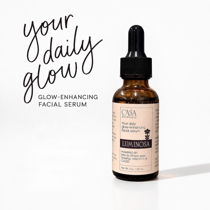May include: A brown glass bottle of facial serum with a black dropper. The label reads "Luminosa" and "Your daily glow-enhancing facial serum." The text "your daily glow" is written in cursive. The bottle contains 1 oz / 30 mL of product.