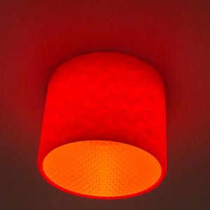May include: A red ceiling light fixture with a honeycomb pattern on the inside.