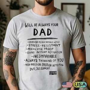 May include: A light gray t-shirt with the words "WILL BE ALWAYS YOUR DAD" in large black letters. Below, a list of qualities is printed in black. The shirt also has a small American flag and the word "USA" printed on it.