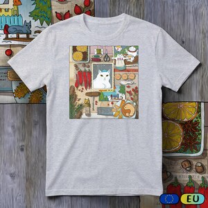 Könnte beinhalten: Hellgraues T-Shirt mit einem farbenfrohen Grafikdesign. Es zeigt eine weiße Katze, rote Chilischoten und weitere Küchenillustrationen, alles vor einem Holz-Hintergrund, was ein charmantes, künstlerisches Design ergibt.