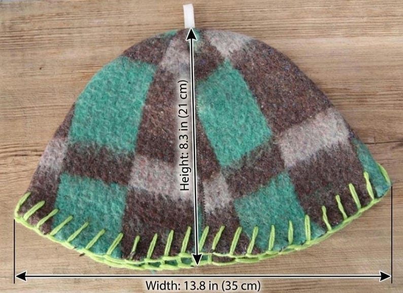 Puede incluir: Un calentador de t&eacute; hecho a mano con un patr&oacute;n de cuadros en tonos verdes, marrones y grises. El calentador mide 21 cm de alto y 35 cm de ancho, con un borde cosido en verde lima y un lazo blanco en la parte superior.