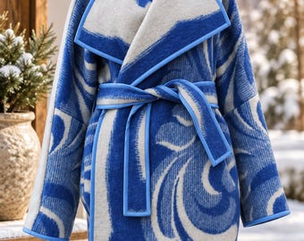 May include: A mid-length coat featuring a bold blue and white swirling pattern. The garment has a wide lapel, long sleeves, and a matching tie belt at the waist. The edges of the coat, lapels, and belt are finished with a solid light blue trim.