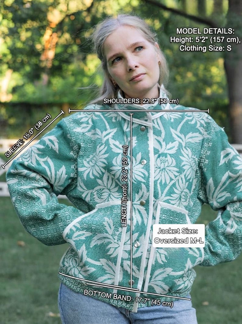 May include: An oversized M-L jacket in teal and white with a floral pattern, featuring a front button closure and white trim. Measurements include a 15.0 inch sleeve, 22.8 inch shoulders, 23.2 inch front length, and a 17.7 inch bottom band.