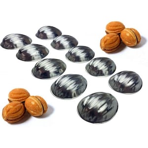 May include: Set of ten silver-colored metal molds shaped like half a walnut shell. The molds are arranged in two rows of five.