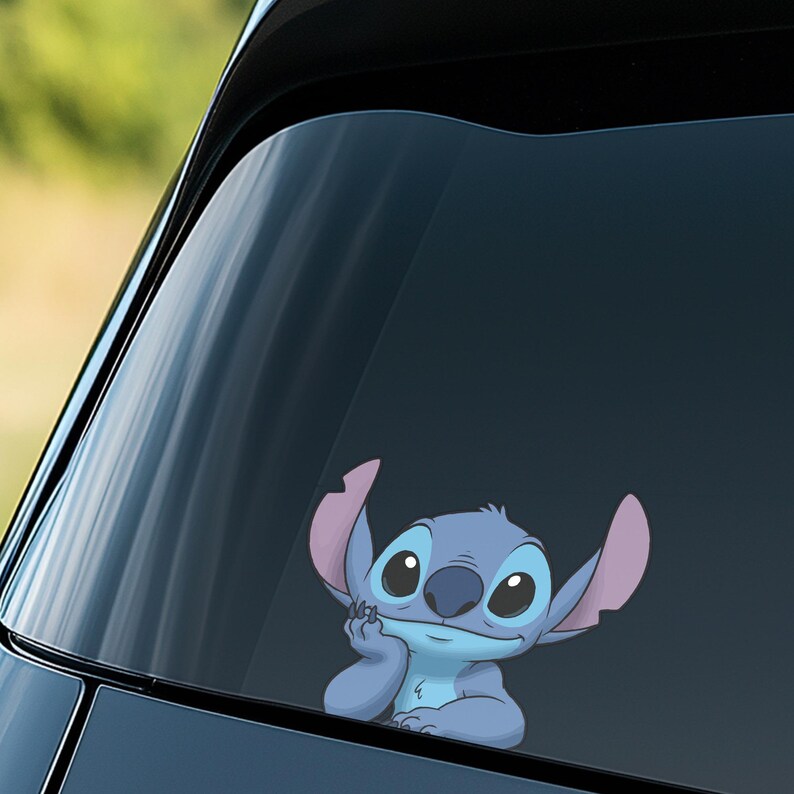 May include: A blue and pink Stitch decal is affixed to a car window. The cartoon character is depicted with a thoughtful expression, resting his chin on his hand. The decal is a fun accessory for car enthusiasts.