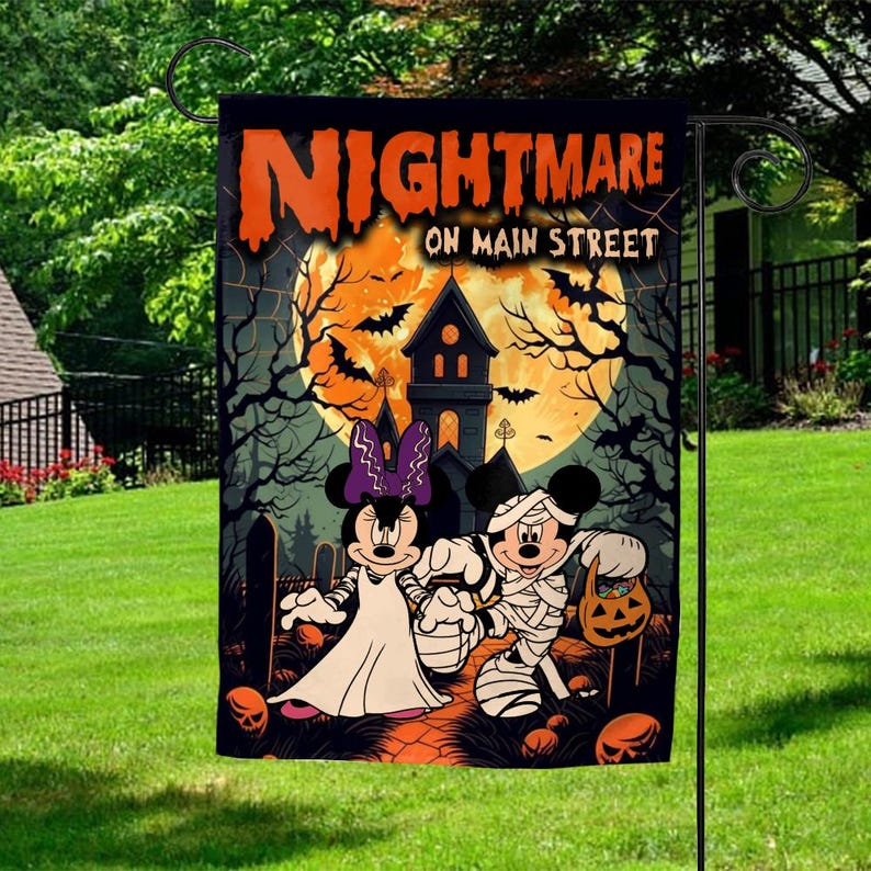 K&ouml;nnte beinhalten: Halloween-Gartenflagge mit Minnie Mouse als Braut und Mickey Mouse als Mumie. Die Flagge zeigt "Nightmare on Main Street" in Orange, vor einem gruseligen Hintergrund mit einem Spukhaus, Flederm&auml;usen und einem Vollmond.