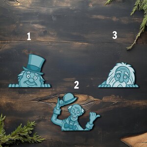 May include: Three teal-colored cartoon ghost figures on a dark wood background. One figure wears a top hat, another holds a hat, and the third has long white hair. The figures are peeking over a ledge, creating a playful, spooky theme.