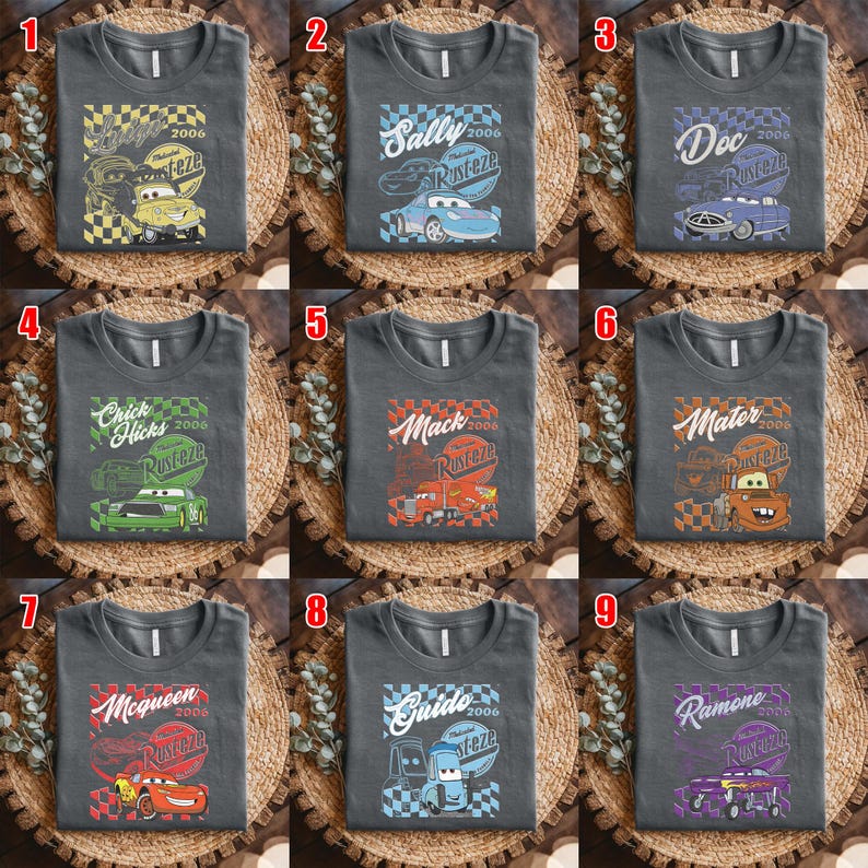 May include: Nine charcoal gray t-shirts with different cartoon car graphics. Each shirt features a car character's name, the year 2006, and the word "Rusteze". The cars are in various colors, including yellow, blue, purple, green, red, and orange.
