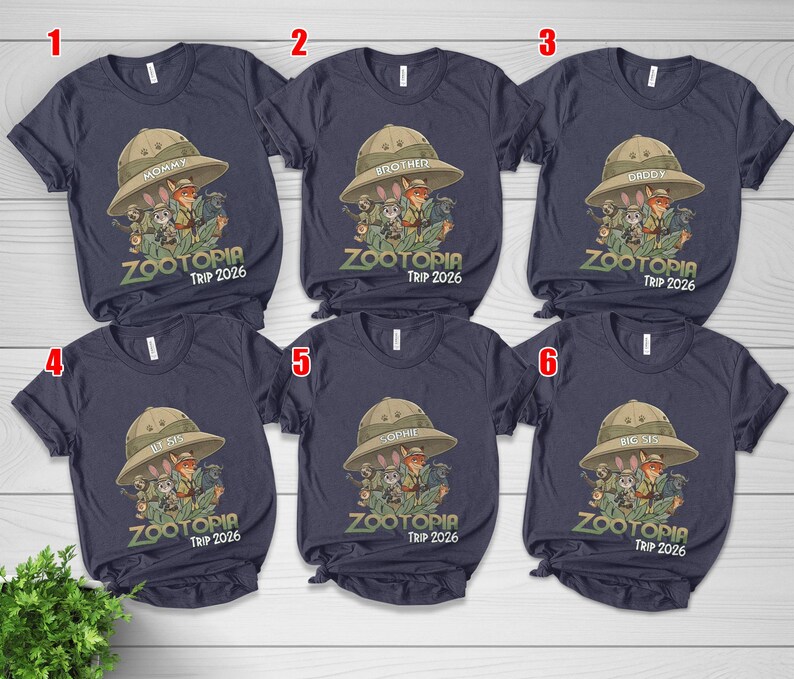 May include: Navy blue t-shirts with a Zootopia graphic featuring characters in safari hats. Each shirt has a different family member's name above the graphic and "Zootopia Trip 2026" below.