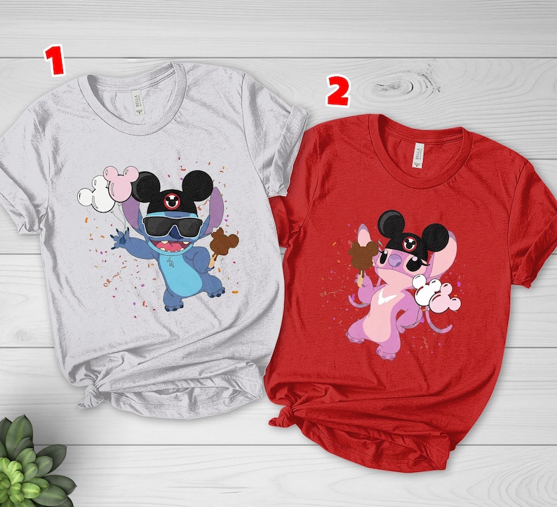 K&ouml;nnte beinhalten: Zwei kurz&auml;rmelige T-Shirts. Eines ist wei&szlig; mit einer blauen Zeichentrickfigur mit Sonnenbrille, schwarzem Hut und Luftballons und Eis. Das andere ist rot mit einer rosa Zeichentrickfigur, die Eis und Luftballons h&auml;lt.
