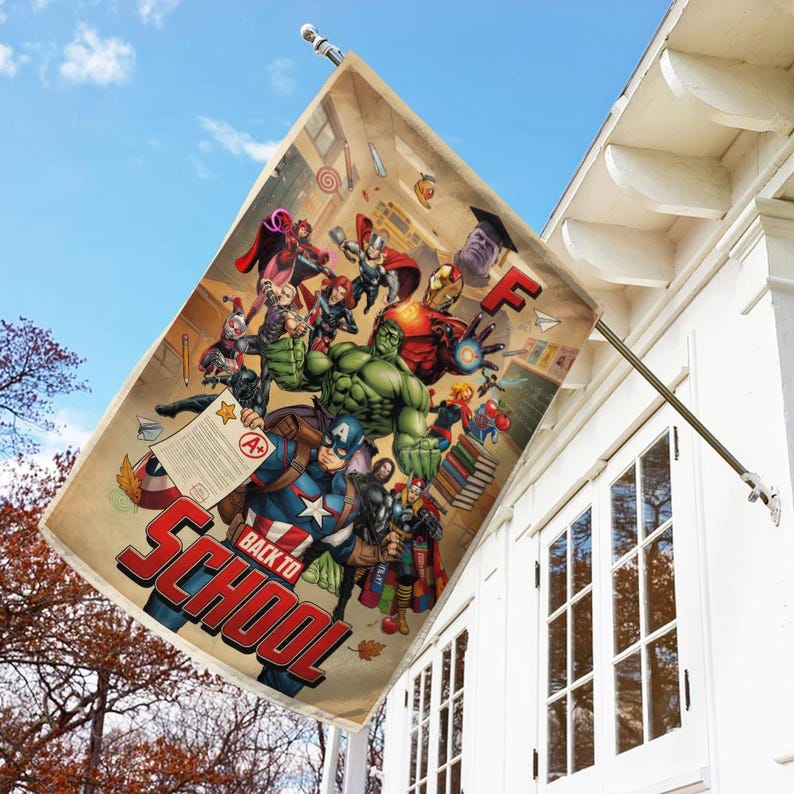 May include: A rectangular flag featuring a collage of Marvel superheroes with the text "BACK TO SCHOOL" in red and blue. The flag is beige with a school-themed background and is hanging outside a white building.