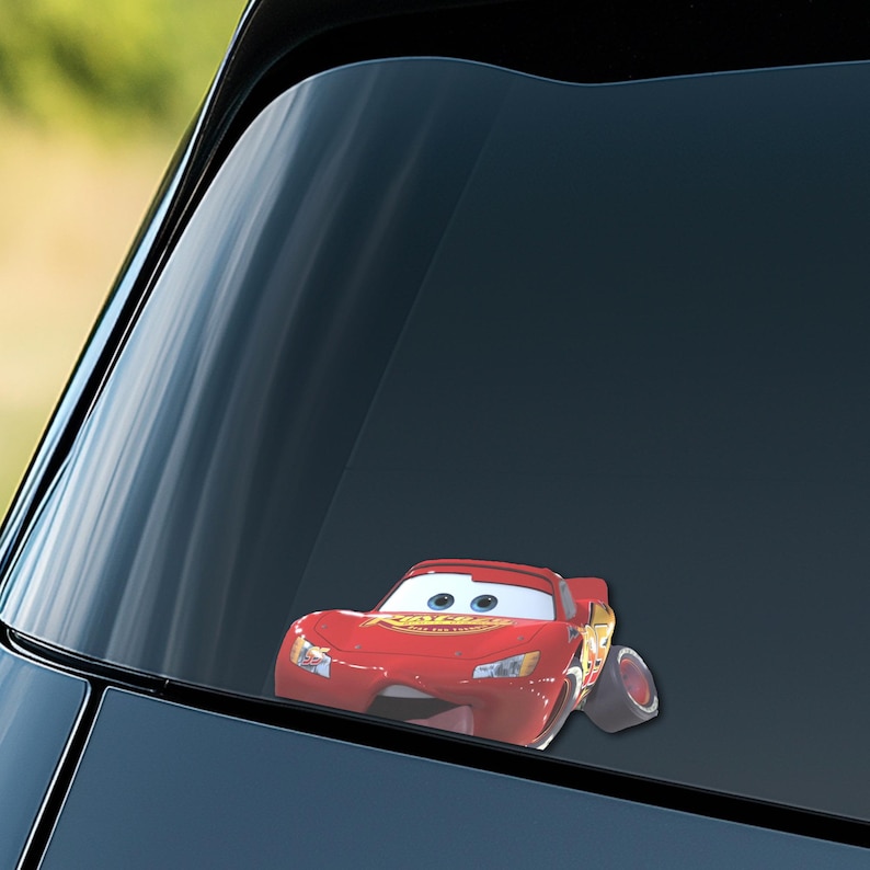 May include: A red Lightning McQueen car sticker is affixed to a car window. The sticker features the animated character with his signature red paint job, eyes, and the word "Rust-eze" on the side. The sticker is a fun accessory for car enthusiasts.