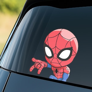 May include: A cartoon sticker of Spider-Man, featuring a red and blue color scheme. The sticker shows Spider-Man's head and arm, with his hand extended. The sticker is designed to be placed on a car window.