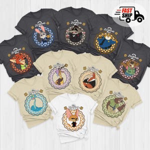 May include: A collection of Zootopia-themed t-shirts in various colors, including gray, tan, and white. Each shirt features a different character from the movie within a circular design, with the Zootopia logo at the top. The shirts are short-sleeved.
