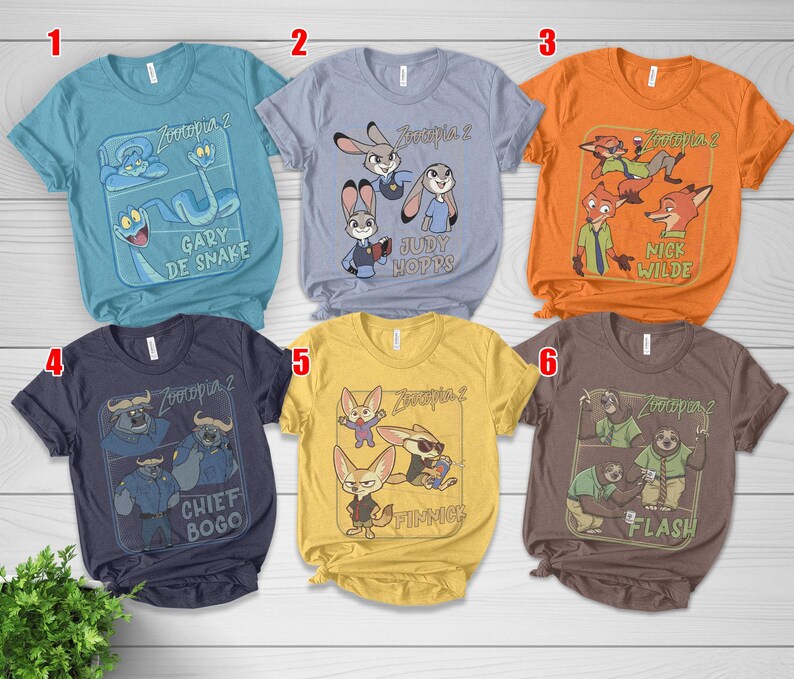 Pode incluir: Seis camisetas de manga curta com personagens de "Zootopia 2". As camisetas s&atilde;o em v&aacute;rias cores: azul-petr&oacute;leo, azul claro, laranja, marinho, amarelo e marrom. Cada camiseta tem um design de personagem diferente e o t&iacute;tulo do filme.