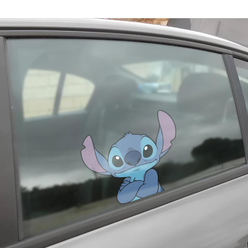 Może przedstawiać: Niebiesko-fioletowa naklejka z kresk&oacute;wki Stitch z Lilo & Stitch, ze skrzyżowanymi ramionami, jest przymocowana do szyby samochodu. Naklejka jest jasnoniebieska z ciemniejszymi niebieskimi cieniami i dużymi, wyrazistymi oczami.