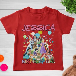 May include: Red t-shirt with a colorful graphic featuring the name "JESSICA", the number "4", and various cartoon princesses. The words "BIRTHDAY GIRL" are also displayed.