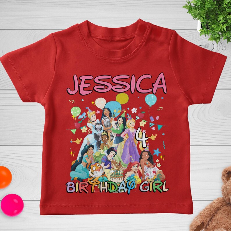 May include: Red t-shirt with a colorful graphic featuring the name "JESSICA", the number "4", and various cartoon princesses. The words "BIRTHDAY GIRL" are also displayed.