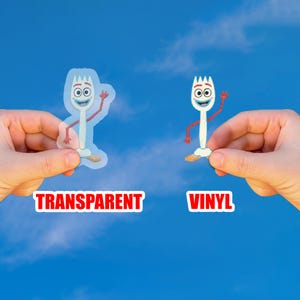 May include: Two stickers featuring the character Forky from Toy Story. One is transparent, the other is vinyl. Both stickers have a white fork body, red arms, and a smiling face. The word "TRANSPARENT" is printed in red on a white background.