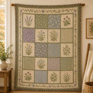 May include: A rectangular woven throw blanket featuring a patchwork design of various botanical illustrations, floral patterns, and striped or checkered squares in shades of green, blue, purple, and cream, finished with a fringed edge on all sides.