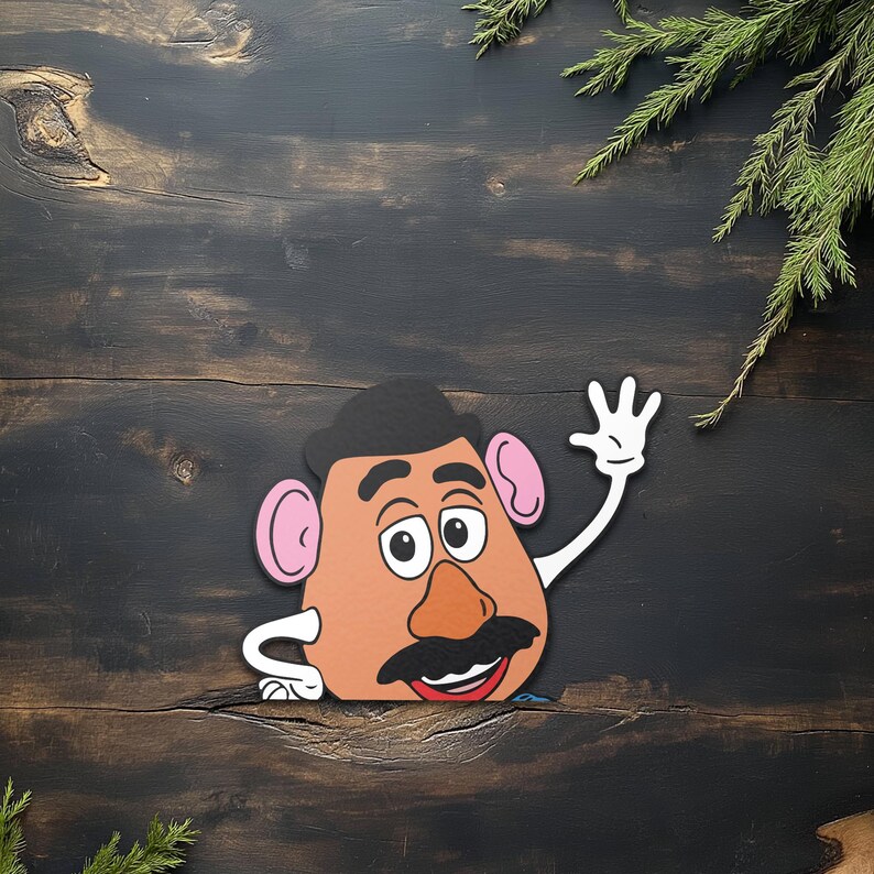 Peut inclure: D&eacute;coupe de dessin anim&eacute; d'un personnage en forme de pomme de terre avec un chapeau noir, une moustache et des oreilles roses, faisant signe avec une main blanche. Le personnage a une bouche rouge souriante et est pos&eacute; sur un fond en bois sombre avec des brins verts.