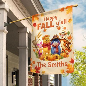 May include: A rectangular outdoor flag with the text "Happy FALL y'all" and the family name "The Smiths". The flag features cartoon characters, pumpkins, and fall leaves. The flag is hanging from a wooden pole.