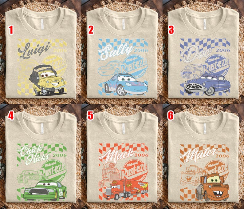 May include: Six beige t-shirts with different Cars movie character designs. Each shirt features a character's name, a checkered flag design, and the text "Rusteze 2006". Characters include Luigi, Sally, Doc, Chick Hicks, Mack, and Mater.