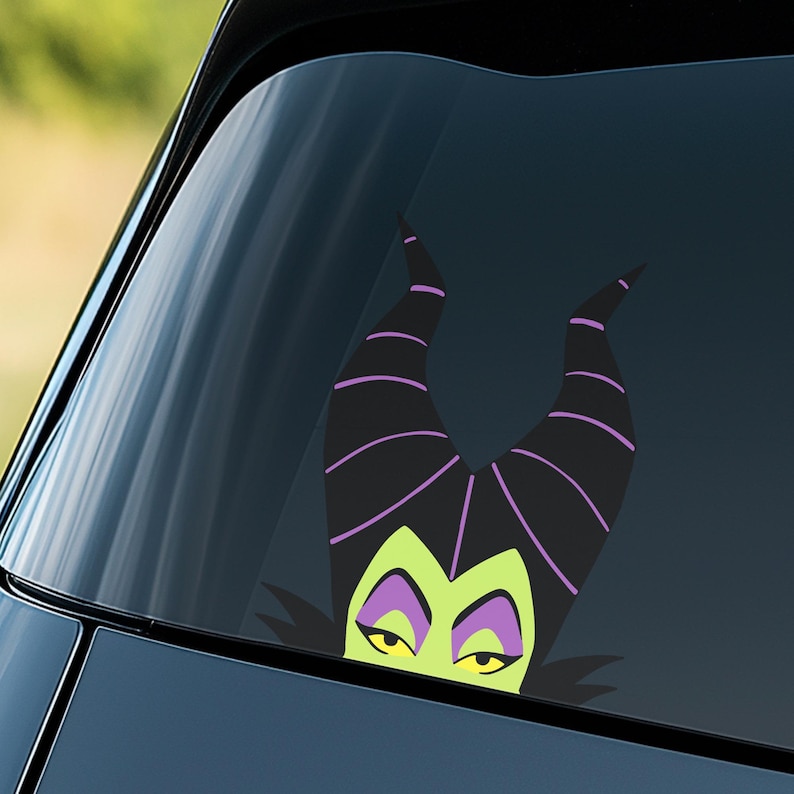 May include: A car window decal featuring a cartoon image of a character with black horns, green skin, and purple accents. The decal is a stylized illustration of a villainous character.