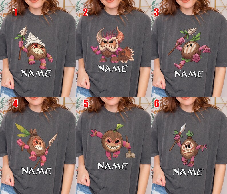 Puede incluir: Seis camisetas grises, cada una con un dise&ntilde;o &uacute;nico de personaje de dibujos animados. Los personajes son criaturas parecidas a cocos con varios accesorios y expresiones. Cada camiseta tiene la palabra "NAME" impresa debajo del personaje.