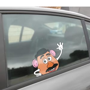Peut inclure: Autocollant de fen&ecirc;tre de voiture repr&eacute;sentant un personnage de dessin anim&eacute; avec un visage orange, une moustache noire et un chapeau noir. Le personnage fait signe avec une main gant&eacute;e de blanc. Con&ccedil;u pour les vitres de voiture.