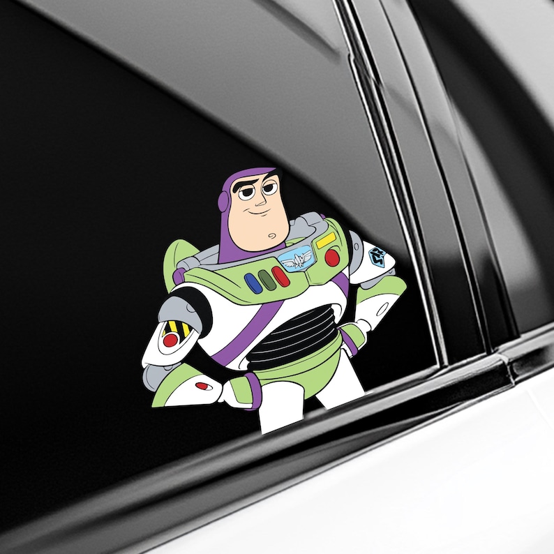 K&ouml;nnte beinhalten: Ein wei&szlig;er, gr&uuml;ner und violetter Buzz Lightyear-Aufkleber mit der Figur aus dem Toy Story-Franchise. Der Aufkleber befindet sich auf einer Autoscheibe, mit verschr&auml;nkten Armen und einem selbstbewussten Gesichtsausdruck.