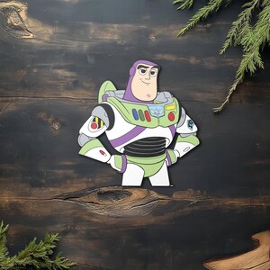 K&ouml;nnte beinhalten: Ein farbenfroher Ausschnitt von Buzz Lightyear aus dem Toy Story-Franchise. Die Figur ist in ihrer Weltraumranger-Uniform dargestellt, mit gr&uuml;nen, wei&szlig;en, lila und roten Akzenten. Das Bild ist vor einem dunklen Holzhintergrund platziert.