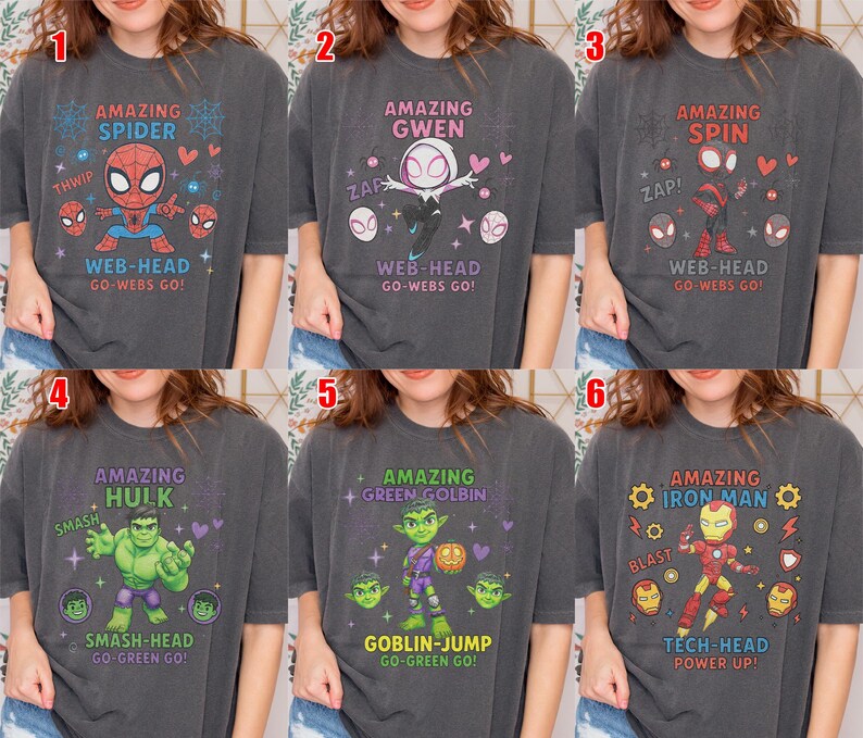 May include: Six charcoal grey t-shirts, each with a superhero design. The shirts showcase characters like Spider-Man, Gwen, and Iron Man, accompanied by phrases such as "Web-Head" and "Tech-Head," along with related illustrations.