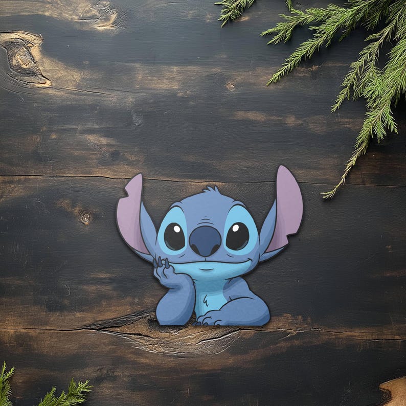 May include: A blue cartoon character with large black eyes, large ears, and a thoughtful expression. The character is resting its chin on its hand. The background is a dark wood surface with green sprigs.