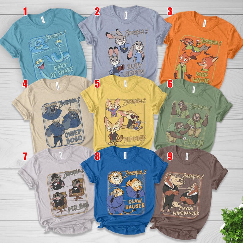 Pode incluir: Nove camisetas coloridas com personagens do filme "Zootopia 2". Cada camisa exibe um personagem ou grupo de personagens diferente com seus nomes. As camisas s&atilde;o de v&aacute;rias cores, incluindo azul, laranja, amarelo e cinza.