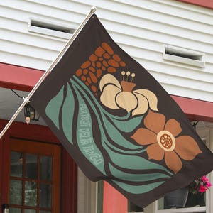 May include: A brown flag with a green, white, and orange floral design. The text "Fox Trot Delta Tango" is printed on the flag.