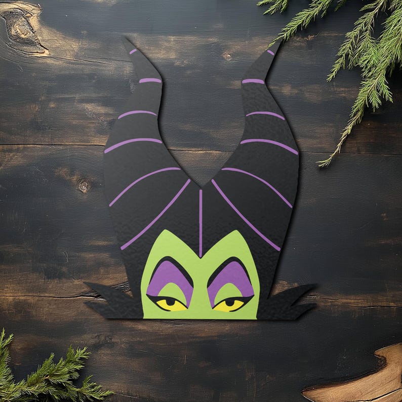 May include: A wooden cutout of a character's head, featuring large black horns with purple stripes, a green face, purple eyeshadow, and yellow eyes. The cutout is set against a dark wood background with sprigs of greenery.