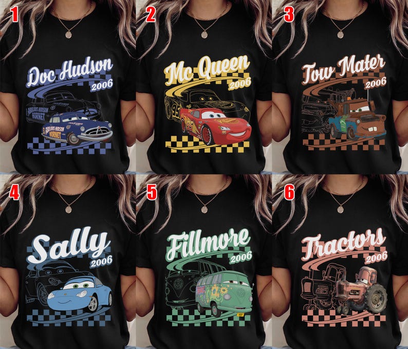 May include: A black t-shirt featuring six different character designs from the movie Cars. Each design includes the character name, the year 2006, a line art sketch, a colored illustration of the vehicle, and a checkered flag pattern at the bottom.