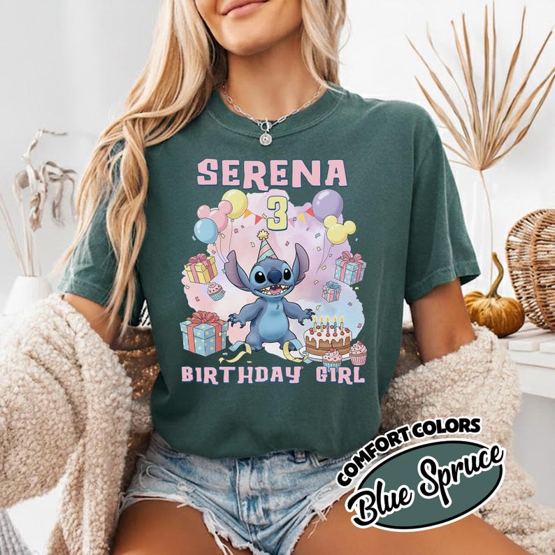 Peut inclure: Un t-shirt vert fonc&eacute; avec un motif du personnage Stitch portant un chapeau de f&ecirc;te, entour&eacute; de ballons, de cadeaux et d'un g&acirc;teau d'anniversaire. Le texte indique SERENA 3 BIRTHDAY GIRL en lettres roses. Le t-shirt a un col rond.