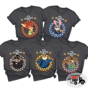 May include: Five dark gray t-shirts featuring characters from the animated film "Zootopia." Each shirt has a circular design with a different character, the film's logo, and a police badge. The characters include a fox, rabbit, and others.