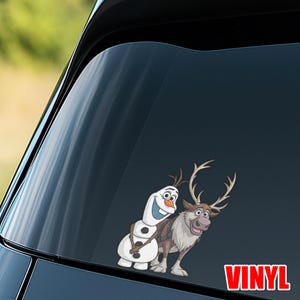 Puede incluir: Una calcoman&iacute;a de vinilo con los personajes animados Olaf el mu&ntilde;eco de nieve y Sven el reno de la pel&iacute;cula Frozen. Olaf es blanco con una nariz de zanahoria y una gran sonrisa. Sven es marr&oacute;n con grandes cuernos. La palabra "VINYL" est&aacute; en rojo.