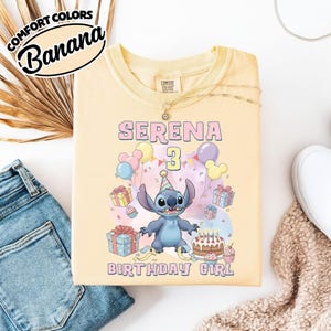 Peut inclure: Un t-shirt jaune p&acirc;le avec une illustration du personnage Stitch portant un chapeau de f&ecirc;te, entour&eacute; de ballons, de cadeaux, d'un g&acirc;teau d'anniversaire avec des bougies et du texte "SERENA 3 BIRTHDAY GIRL" en rose clair et jaune.