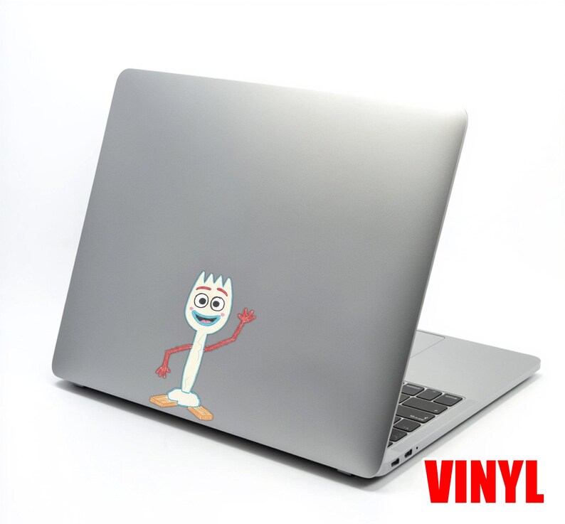 May include: A gray laptop with a colorful vinyl sticker of the character Forky from Toy Story. The sticker is white with a fork head, blue mouth, and red arms. The word "VINYL" is printed in red.