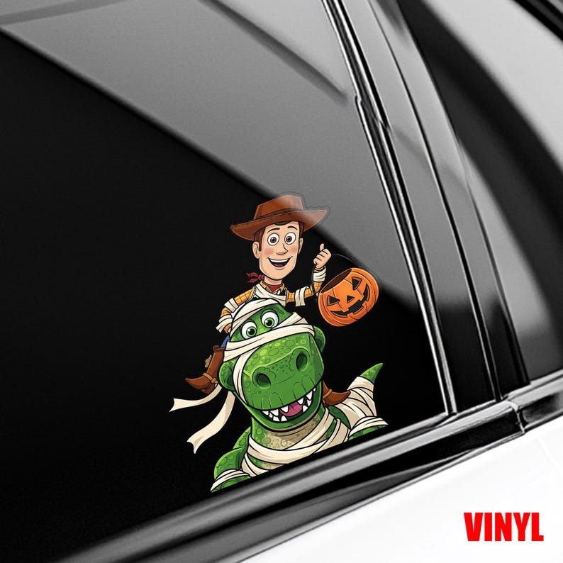 Puede incluir: Una calcoman&iacute;a de vinilo con una caricatura de Woody de Toy Story montando un dinosaurio verde envuelto en vendas. Woody sostiene una linterna de calabaza. La palabra "VINYL" est&aacute; impresa en rojo en la parte inferior.