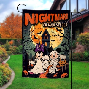 K&ouml;nnte beinhalten: Halloween-Gartenflagge mit Mickey und Minnie Mouse in Kost&uuml;men. Die Flagge zeigt "Nightmare on Main Street" mit einem Spukhaus, Flederm&auml;usen und einem Vollmond. Die Flagge ist schwarz mit orangefarbenen und wei&szlig;en Details.