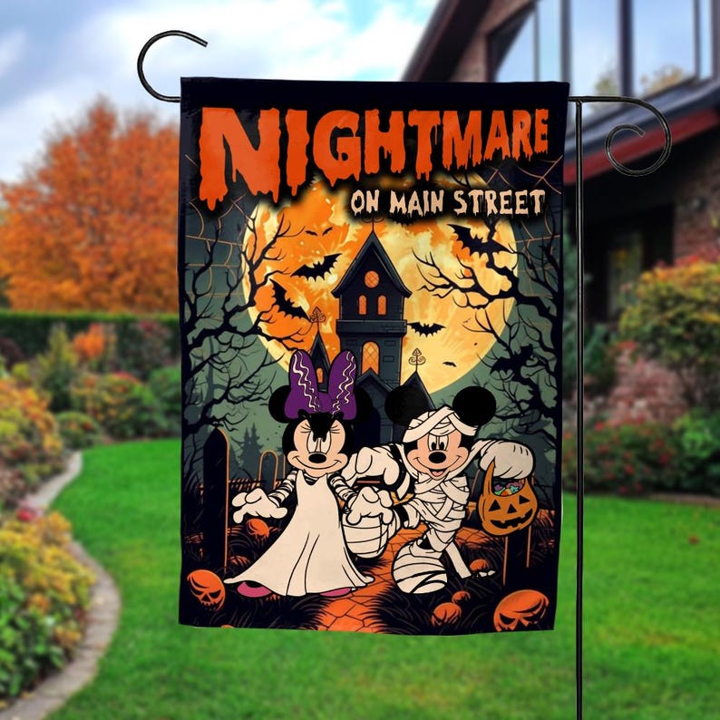 K&ouml;nnte beinhalten: Halloween-Gartenflagge mit Mickey und Minnie Mouse in Kost&uuml;men. Die Flagge zeigt "Nightmare on Main Street" mit einem Spukhaus, Flederm&auml;usen und einem Vollmond. Die Flagge ist schwarz mit orangefarbenen und wei&szlig;en Details.