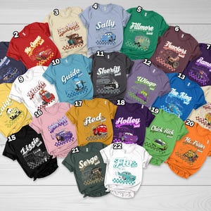 May include: A collection of twenty-two short-sleeved t-shirts in various colors, each featuring a unique character graphic from the movie Cars, including names like Doc Hudson, Tow Mater, Sally, Fillmore, and others, with numbered labels from 1 to 22.