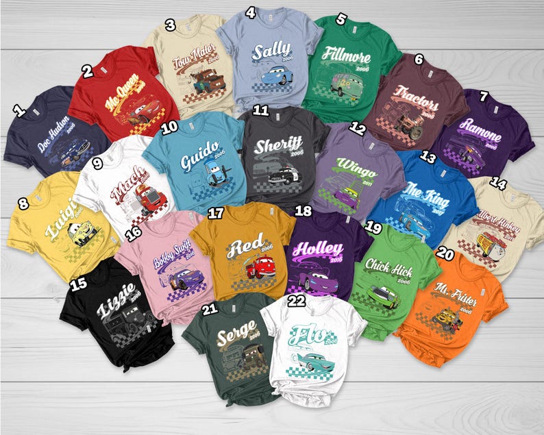 May include: A collection of twenty-two short-sleeved t-shirts in various colors, each featuring a unique character graphic from the movie Cars, including names like Doc Hudson, Tow Mater, Sally, Fillmore, and others, with numbered labels from 1 to 22.