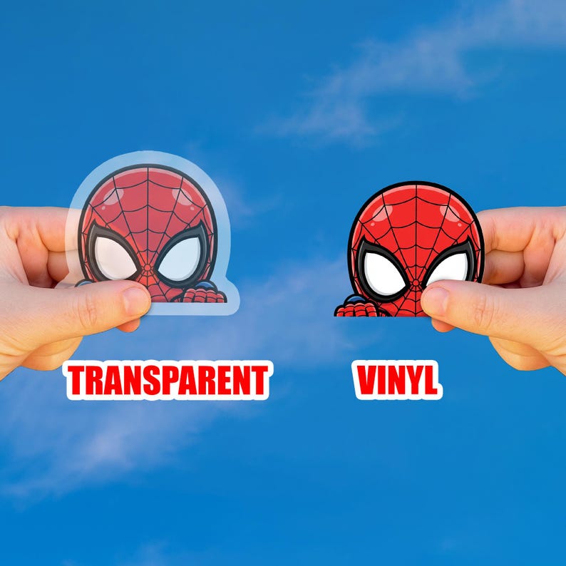 May include: Two Spider-Man stickers are held up against a blue sky. One is transparent, and the other is vinyl. The stickers feature the character's red and black mask with white eyes. The word "TRANSPARENT" is printed in red on a white background, and "VINYL" is printed in red on a white background.